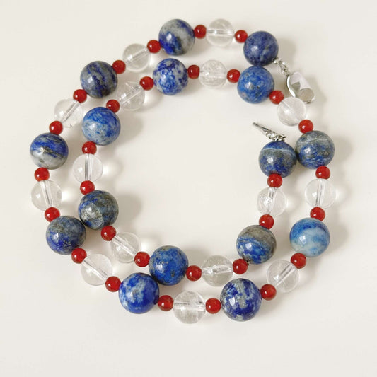 Close-up of blue stone beads, small red chalcedony beads, and clear quartz beads.