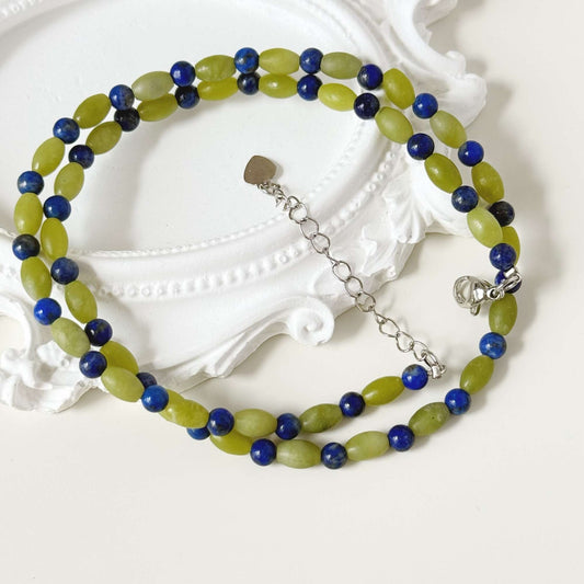 Close-up of lapis blue round beads and soft green oval stone beads with natural variation.
