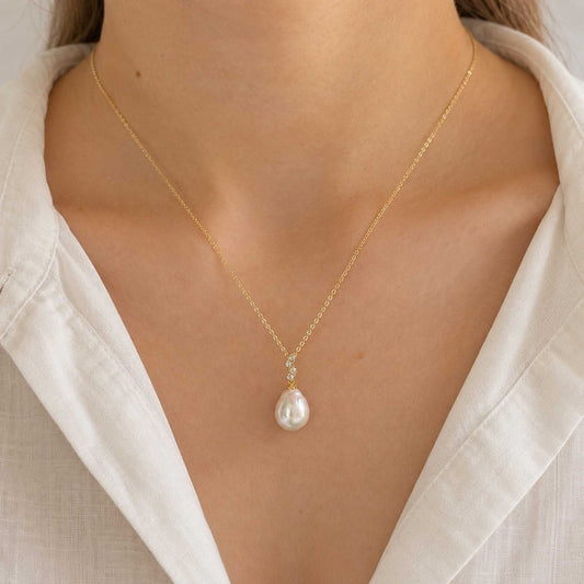 Model wearing the Elara baroque freshwater pearl pendant necklace with a light gold chain