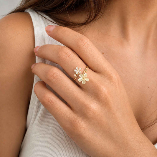 Model wearing an adjustable floral ring with cream flower petals and zircon details.