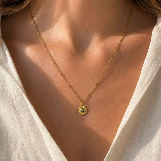 Gold coin pendant necklace with African turquoise worn in warm natural light