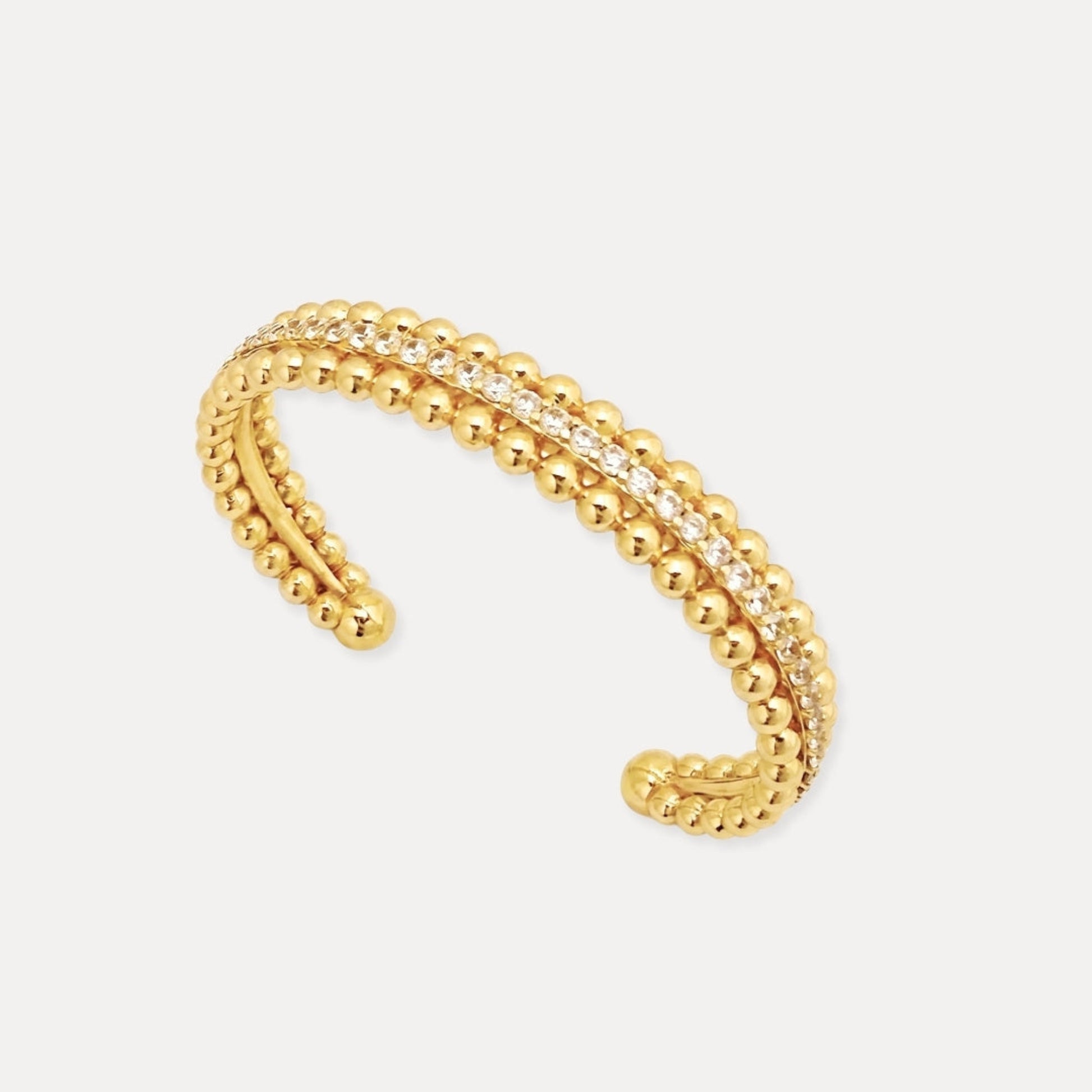 Close-up of gold-tone beaded cuff bracelet with cubic zirconia row detail