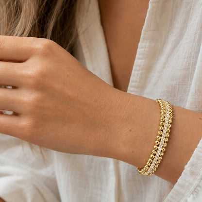 Gold-tone CZ beaded cuff bracelet worn on wrist in natural sunlight