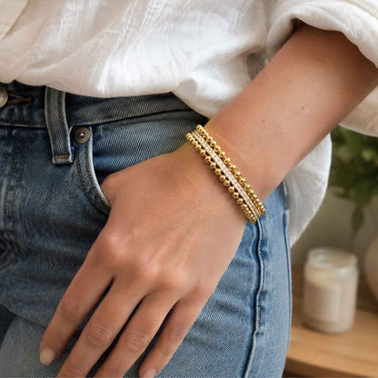 Gold-tone beaded cuff bracelet stacked with everyday bracelets