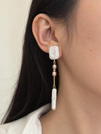 Cadence long pearl drop earring worn in side profile, showing its slender silhouette and soft pink pearl details.