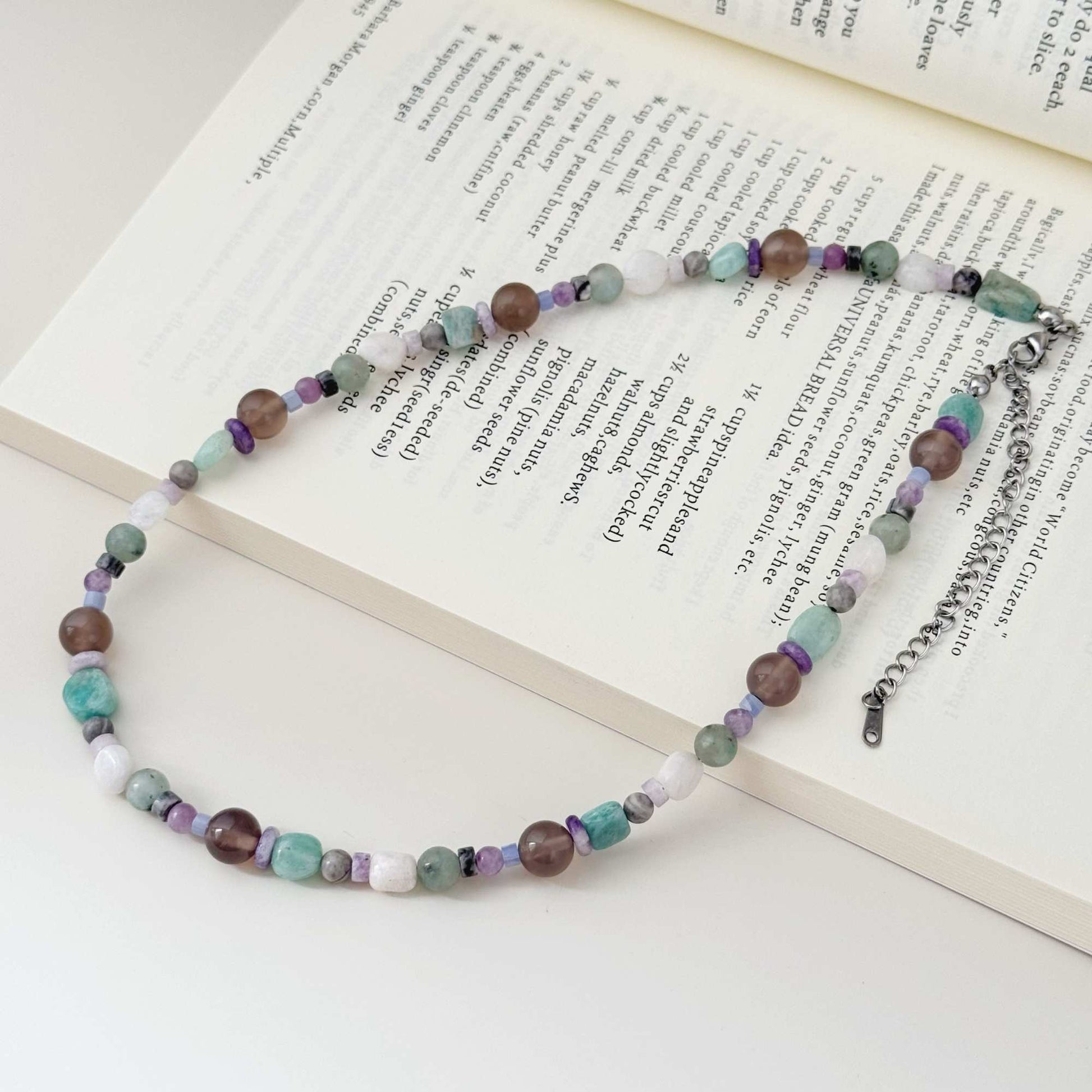 Close-up of mixed stone beads in blue, gray, purple, white, and smoky brown tones.