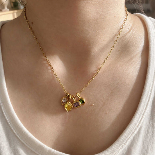Color Notes Charm Necklace worn alone with four colorful charms resting at the center of the neckline
