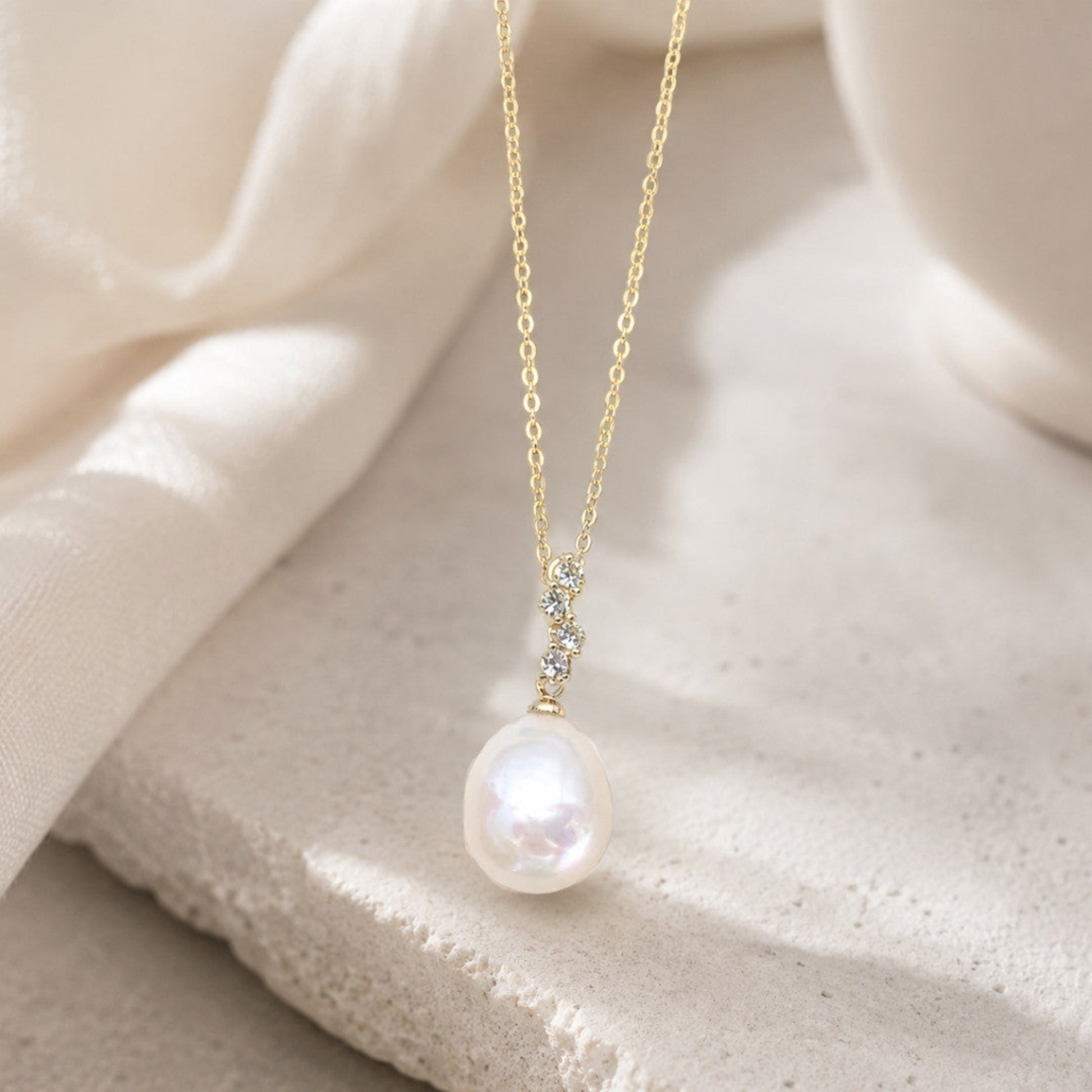 Close-up of baroque freshwater pearl pendant with cubic zirconia accents and light gold-plated setting