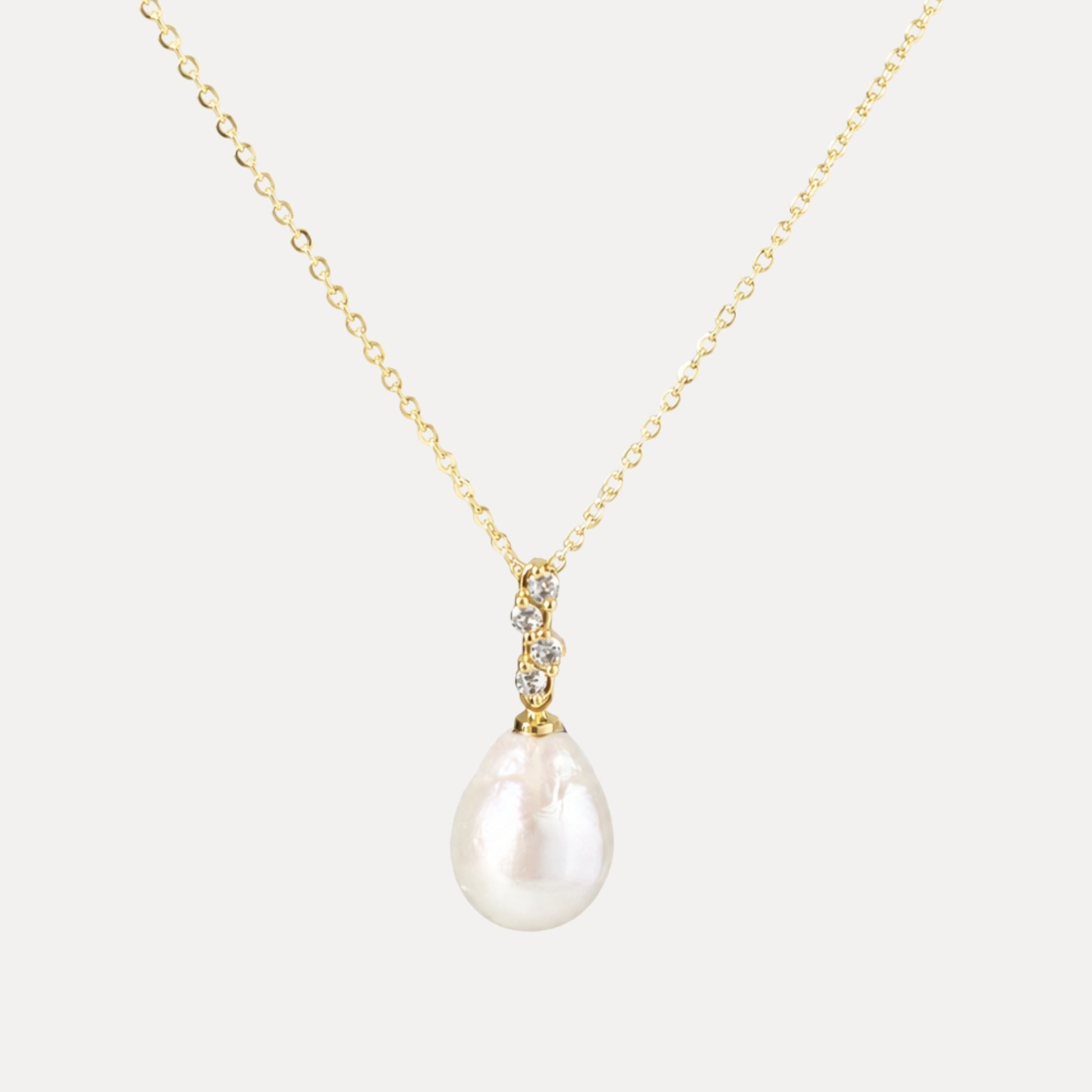 Elara baroque freshwater pearl and cubic zirconia pendant necklace with light gold-plated chain on a soft neutral background