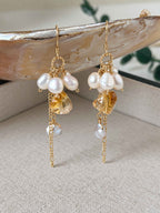 Gleam freshwater pearl and citrine earrings displayed against a natural shell and neutral linen background.