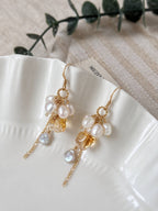Gleam citrine pearl earrings arranged on a white ceramic dish, showing the layered pearl and chain details.