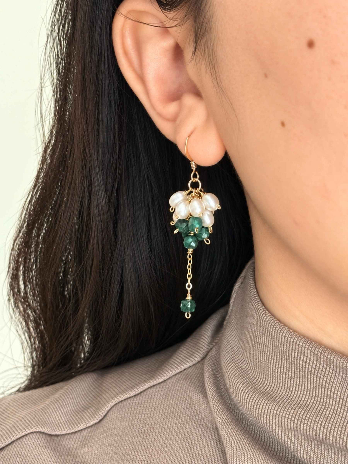 Grove freshwater pearl and malachite earring worn from the front, showing its compact clustered shape and moving green drop.