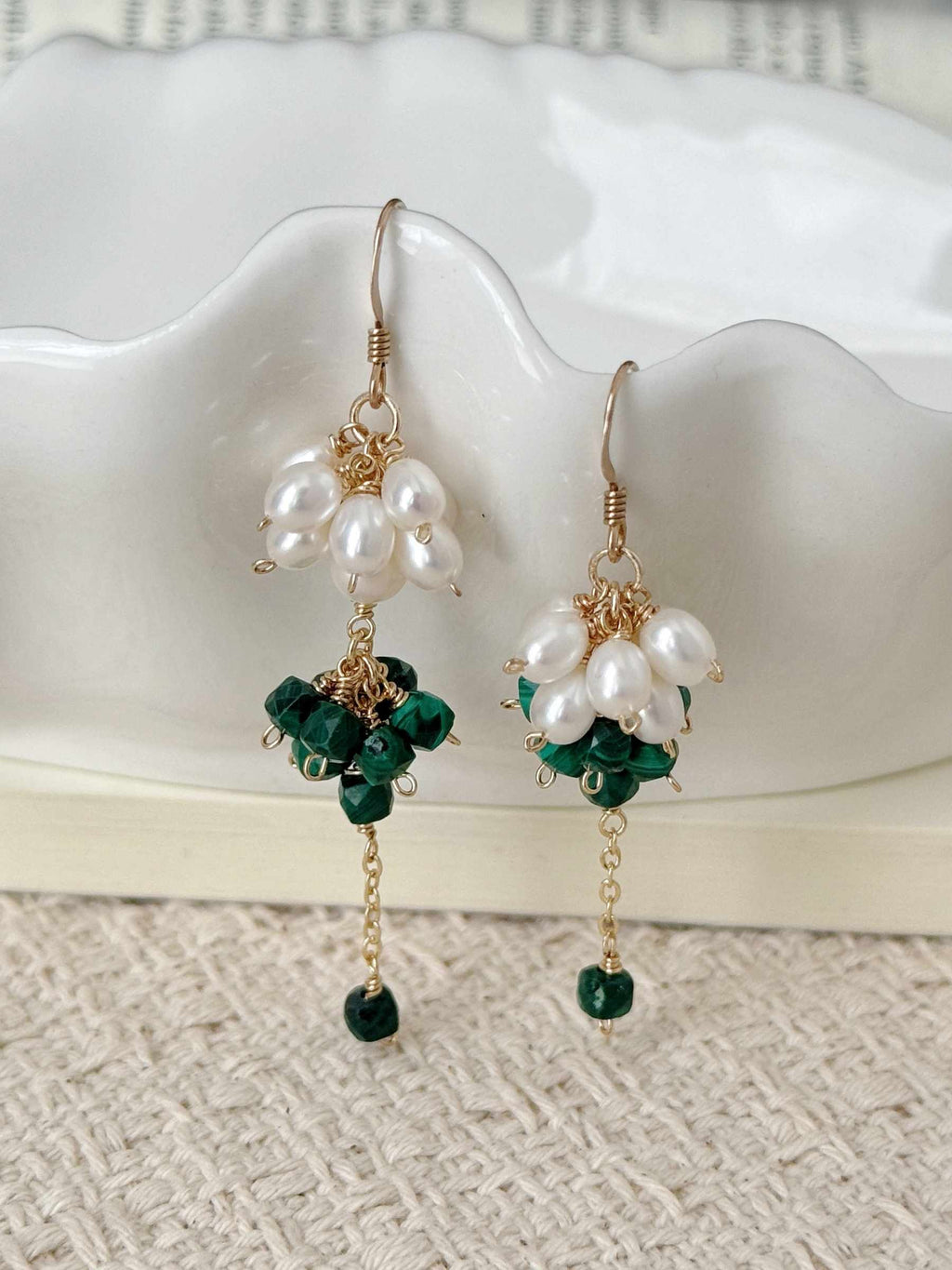 Grove freshwater pearl and natural malachite earrings displayed against a white ceramic dish with delicate gold-filled drops.