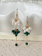 Grove freshwater pearl and natural malachite earrings displayed against a white ceramic dish with delicate gold-filled drops.