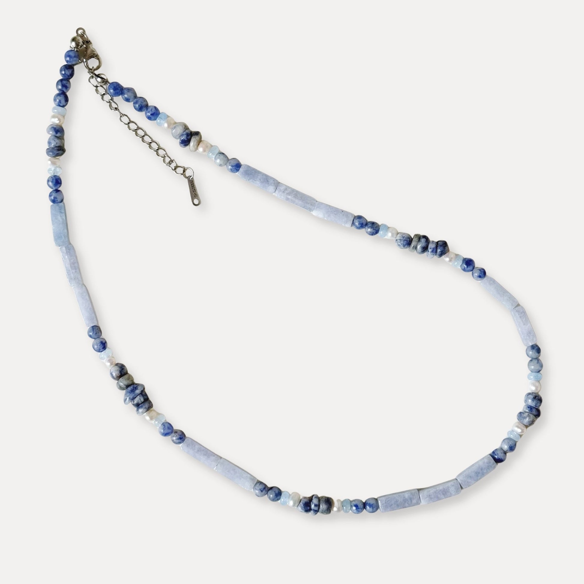 Blue-gray agate and freshwater pearl necklace arranged on a clean light background.