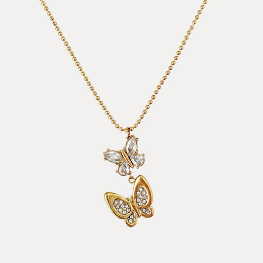 Front view of the In Motion Butterfly Necklace with clear upper butterfly details and a gold stone-set lower butterfly