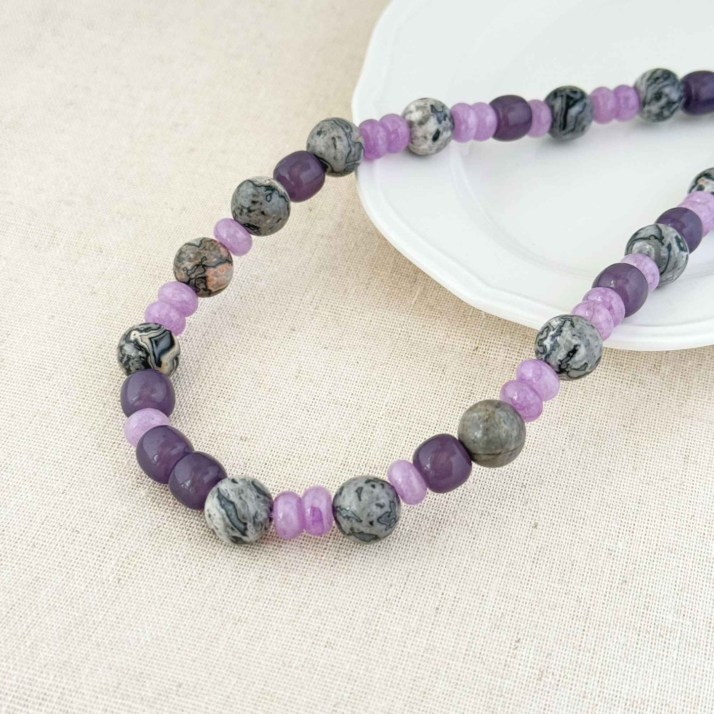 Close-up of lilac purple quartzite beads and gray map stone beads with natural patterns.