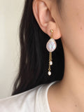 Lilt baroque pearl drop earring worn in side profile, featuring fine gold chains and small pearl accents.