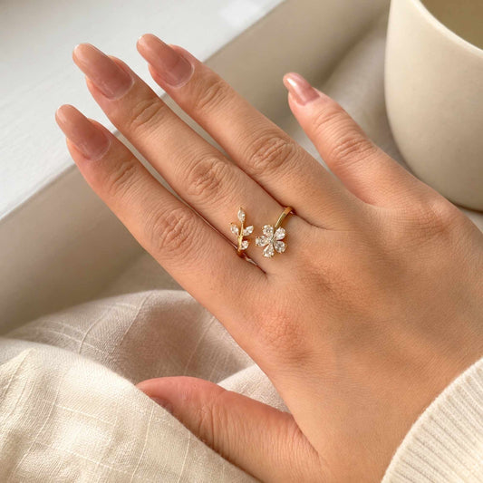 Model wearing a delicate gold floral ring with zircon details.