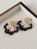 Loom pearl and black agate earrings arranged on a neutral linen jewelry tray.
