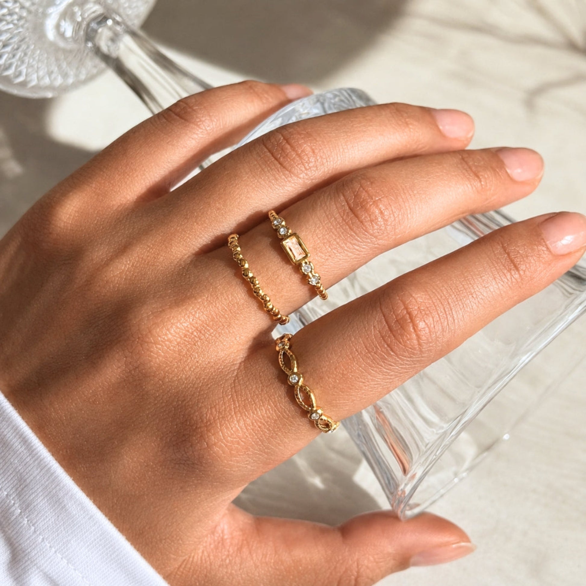 Waterproof gold stainless steel ring set worn in warm natural light