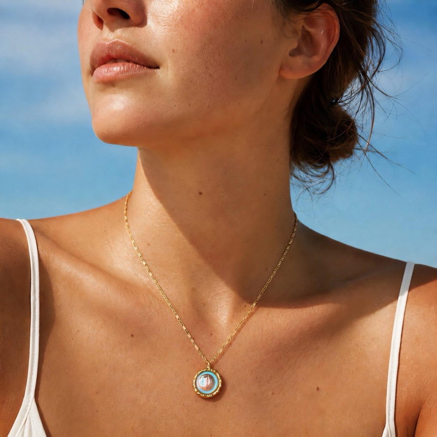 Luminous moonstone pendant necklace worn in warm beach sunlight