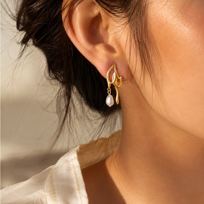 Organic gold freshwater pearl drop earrings worn in warm natural light