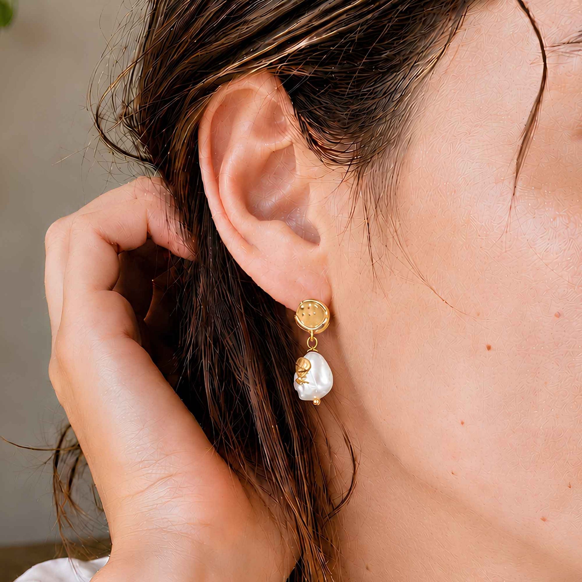 Freshwater pearl drop earrings worn in warm natural light