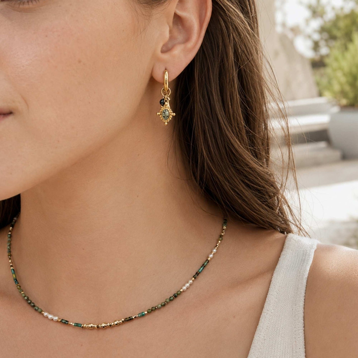 Close-up of natural stone charms on gold stainless steel hoop earrings