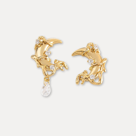 Gold moon earrings with zircon accents and an asymmetrical clear drop detail.