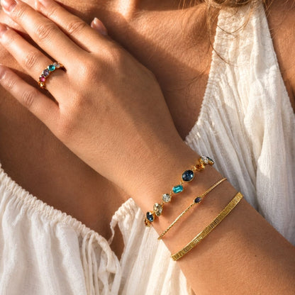 Colorful glass bracelet stacked with gold cuff bracelets