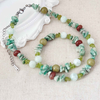 Close-up of green apatite, mixed natural stone beads, olive tones, and stainless steel clasp.