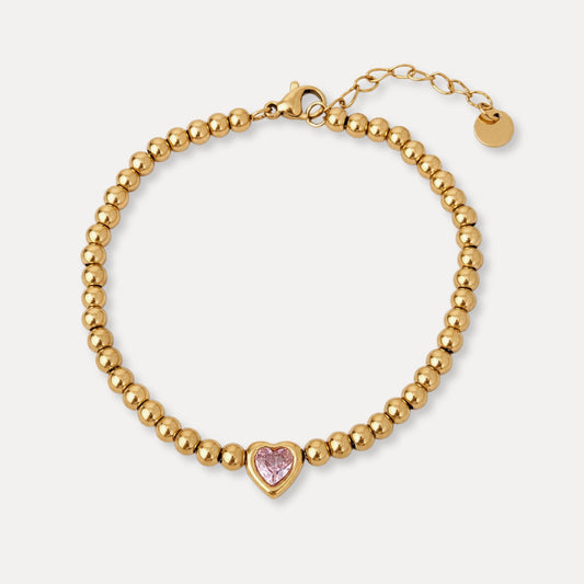 One Heart Bead Bracelet with polished gold beads and a single pink cubic zirconia heart centerpiece