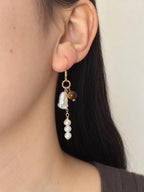 Orbit tiger eye and freshwater pearl drop earring worn in side profile with warm gold-filled details.