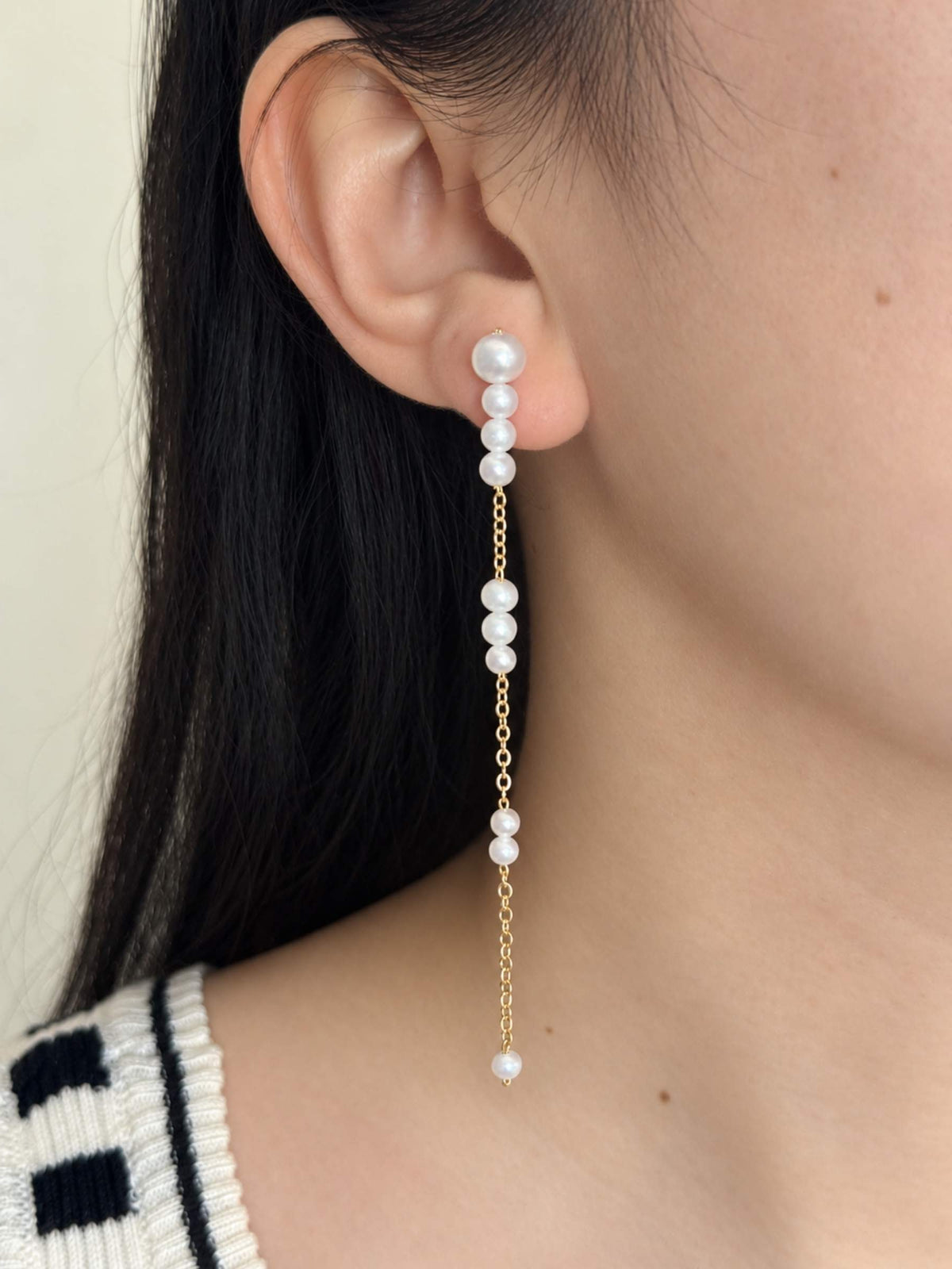 Pace long freshwater pearl drop earring worn in side profile with fine gold-filled chain details.