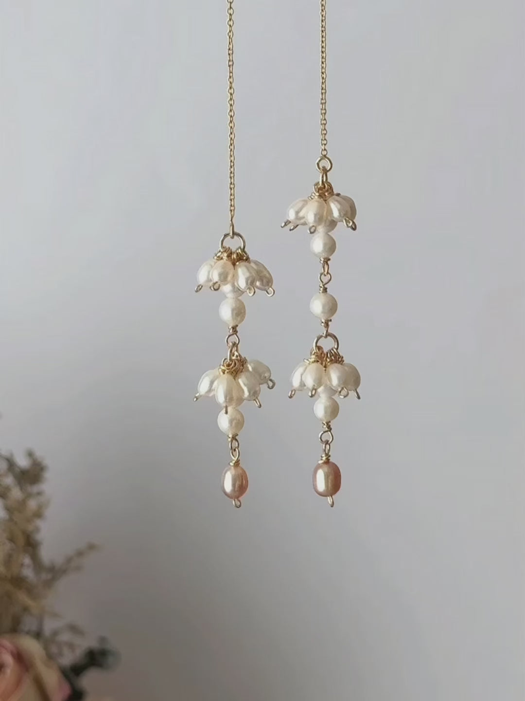 Drift freshwater pearl threader earrings shown suspended and then worn, highlighting the asymmetric pearl clusters and fluid chain movement.