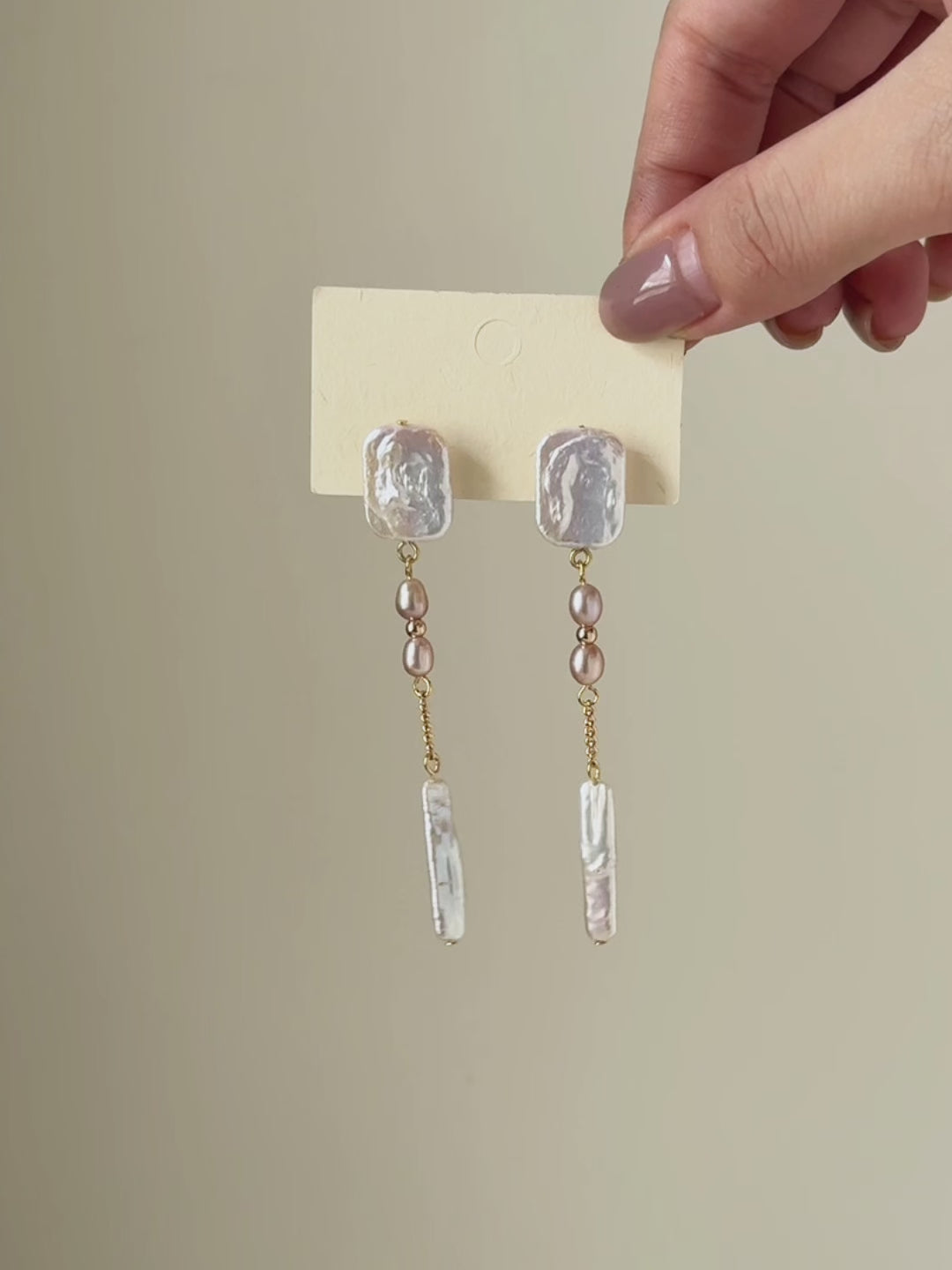 Six-second video transitioning from a full pair display to a close-up worn view, highlighting the earrings’ length, pearl luster and natural movement.