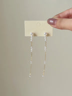 Six-second product video transitioning from the full pair on a display card to a worn close-up, highlighting the earrings’ length and fluid movement.