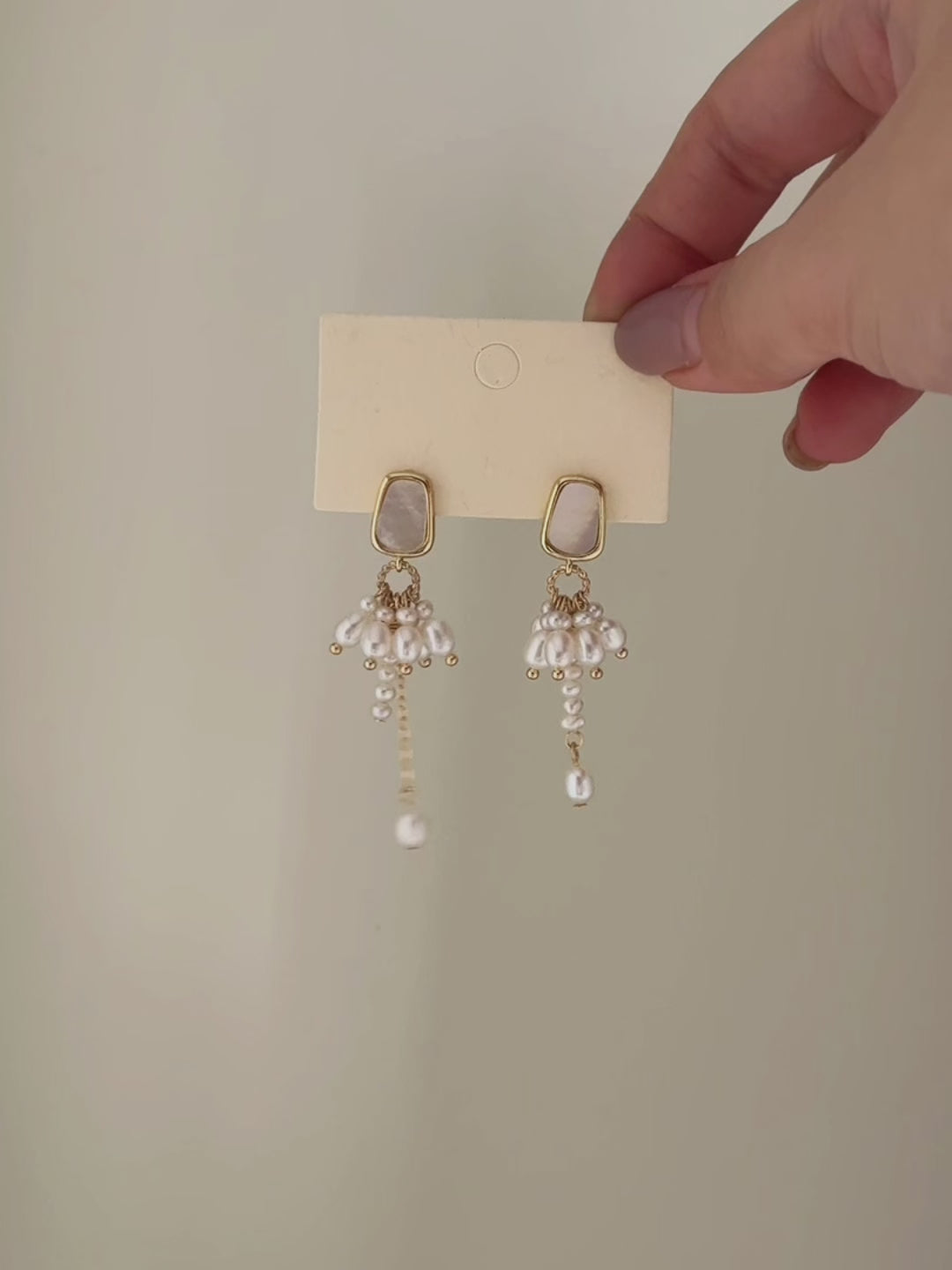 Drape freshwater pearl earrings shown from full product display to worn view, highlighting the asymmetric lengths and gentle movement.