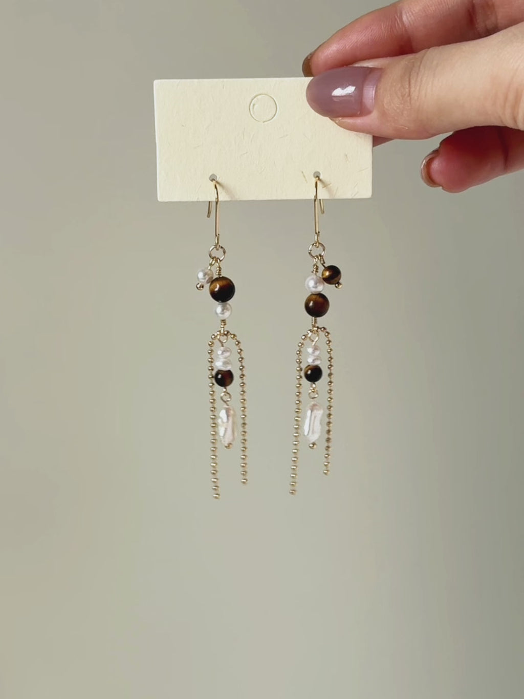 Tether tiger eye and freshwater pearl earrings shown from full product display to worn view, highlighting the long silhouette and fluid movement.
