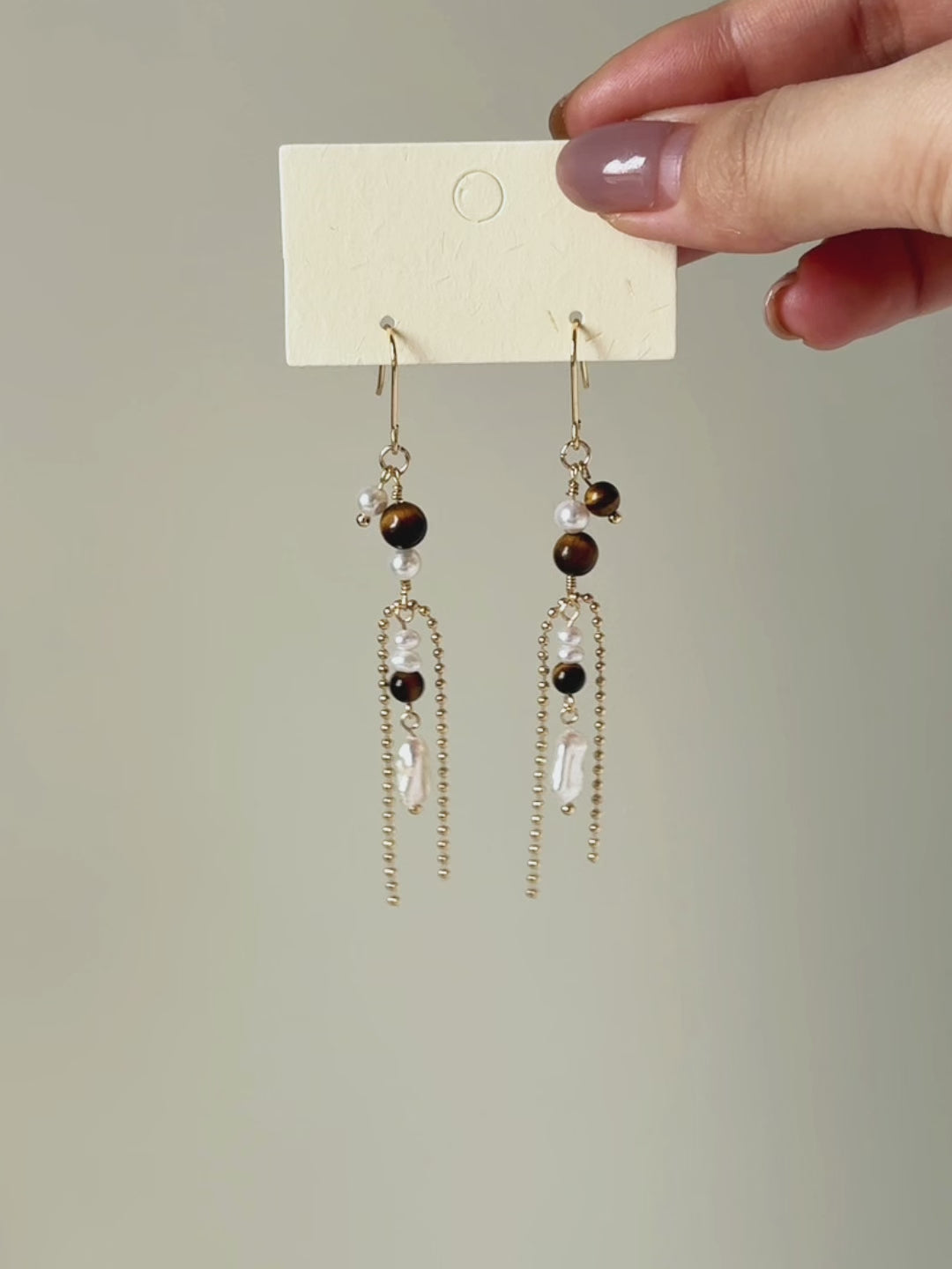 Tether tiger eye and freshwater pearl earrings shown from full product display to worn view, highlighting the long silhouette and fluid movement.