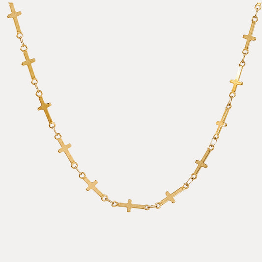 Quiet Faith Cross Chain Necklace arranged beside a white ceramic plate in warm natural light