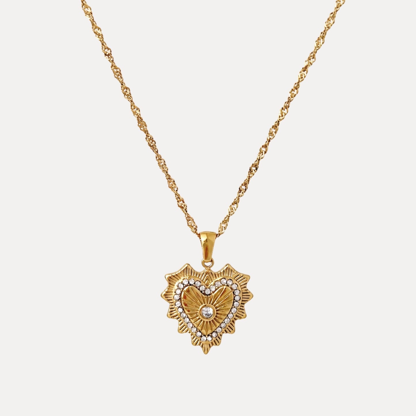 Radiant Heart Pendant Necklace with cubic zirconia details, radiating gold texture and a twisted chain