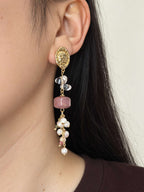 Relic rhodonite pearl earring worn in side profile with clear quartz and clustered gemstone accents.