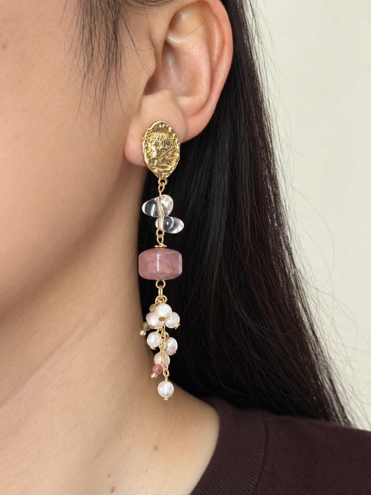 Relic rhodonite pearl earring worn in side profile with clear quartz and clustered gemstone accents.