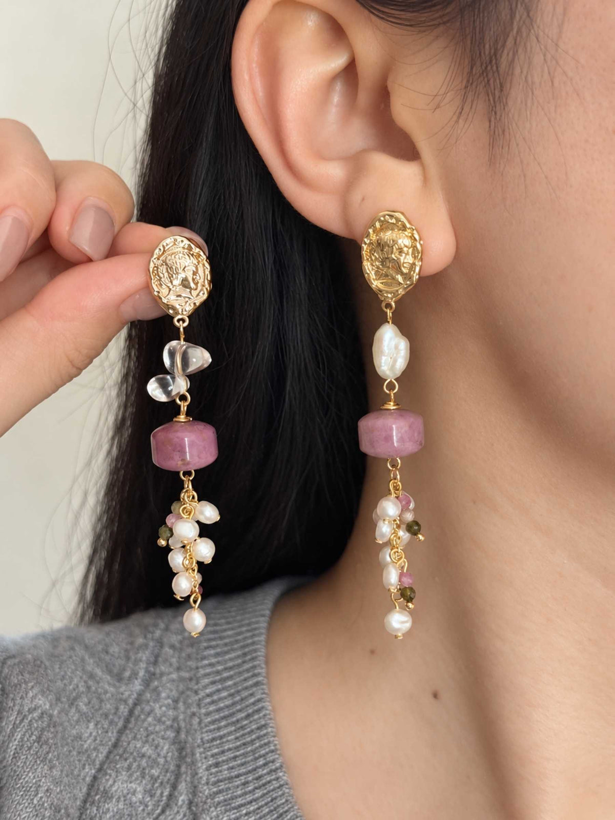 Relic gemstone pearl earrings shown worn and held beside the ear, highlighting their length and natural stone details.