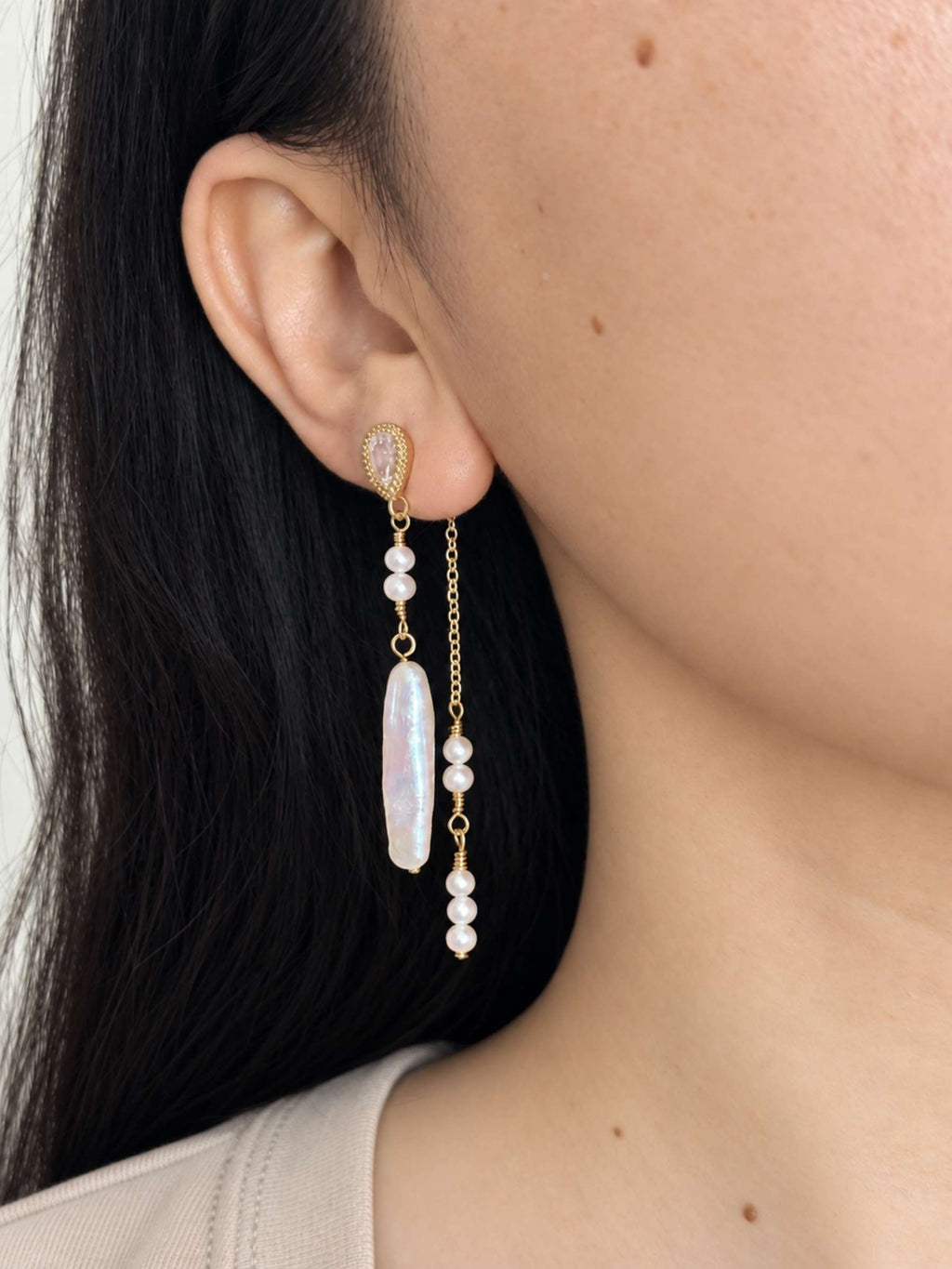 Shift pearl earring worn in its layered two-drop style with a baroque pearl and delicate pearl chain.