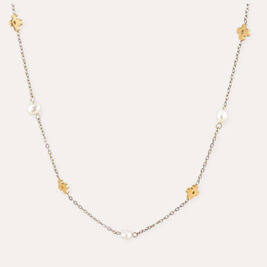 Gold flower necklace with freshwater pearls on a clean light background.
