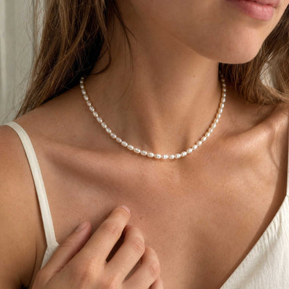 Everyday pearl necklace styled close to the collarbone in soft natural light.