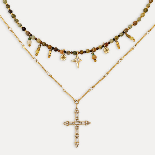 Steadfast Layering Necklace Set with a Tsavorite and Tiger’s Eye necklace layered above a gold cross pendant necklace.
